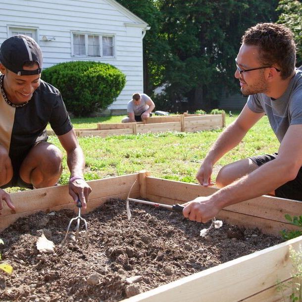 Two students work in Elmira College's community garden